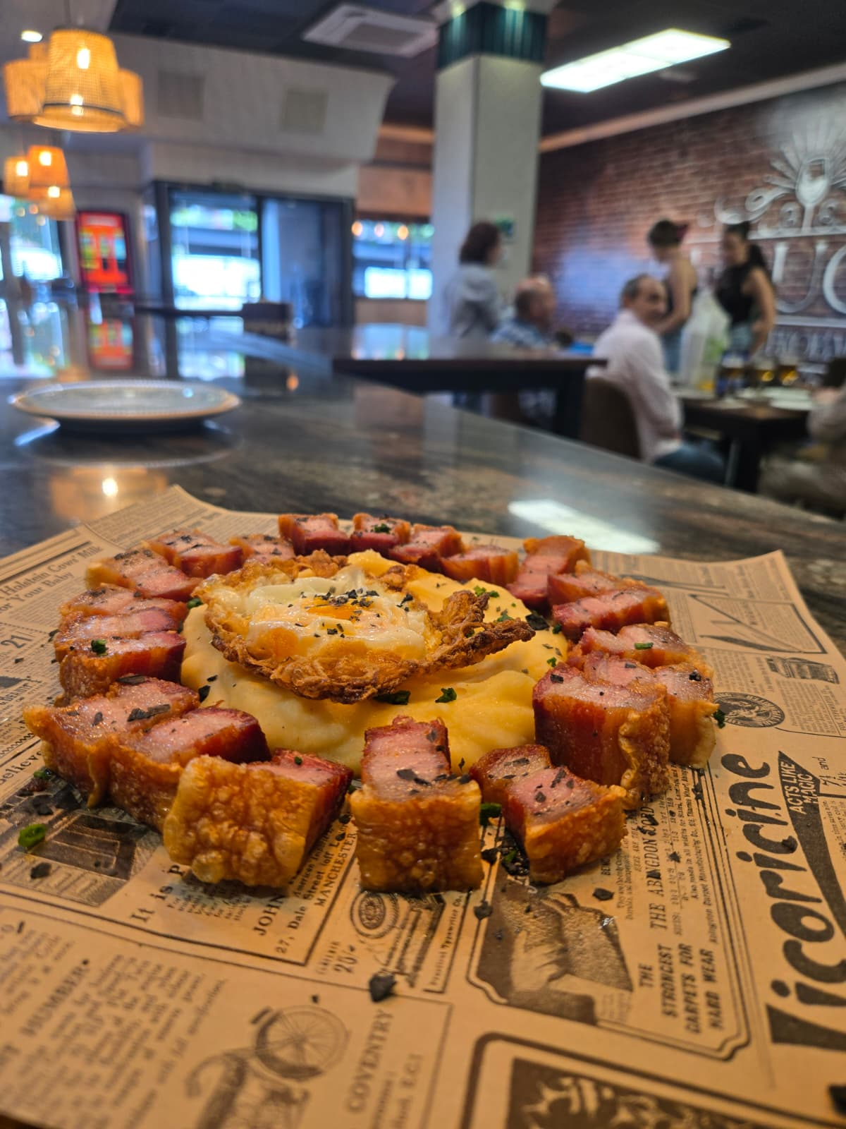 Panceta crujiente con parmentier y huevo frito servida en la barra de D'Luca Gastrobar